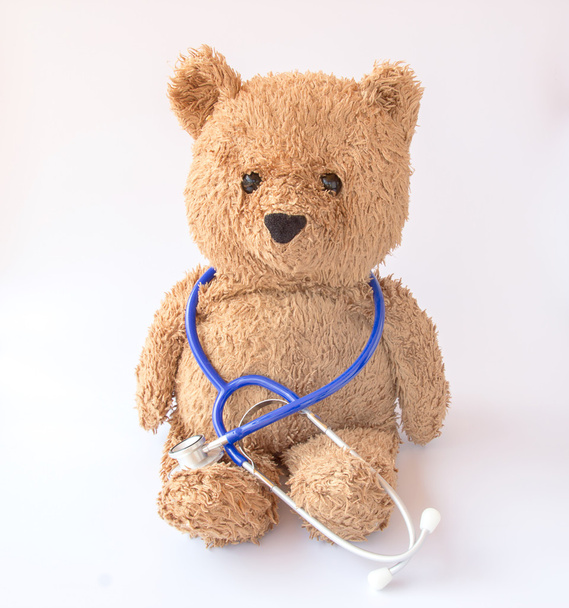 Blauwe stethoscoop en teddy bear op witte achtergrond - Foto, afbeelding