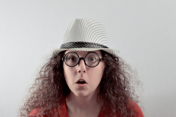 meisje met belachelijk expressie, hoed en bril  - Foto, afbeelding