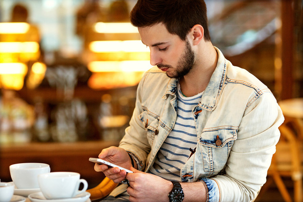 a man sitting in a cafe with a phone in his hand, businesslike,  - Photo, Image