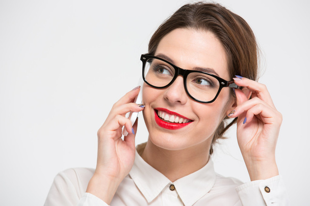 Cheerful pretty business woman in glasses talking on cell phone - Zdjęcie, obraz