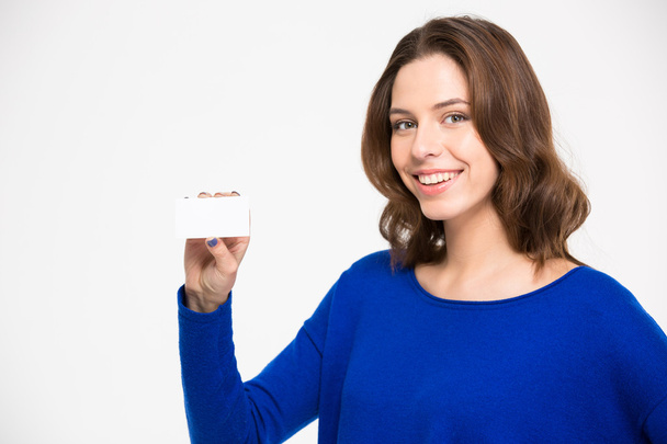 Cheerful beautiul young woman holding blank card and smiling - Fotoğraf, Görsel