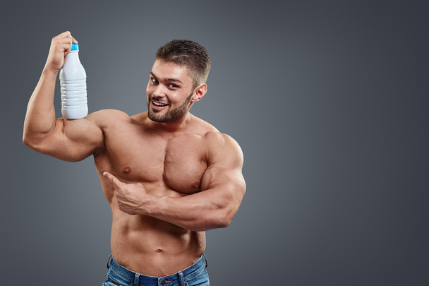 Muscular man with protein drink in shaker - 写真・画像