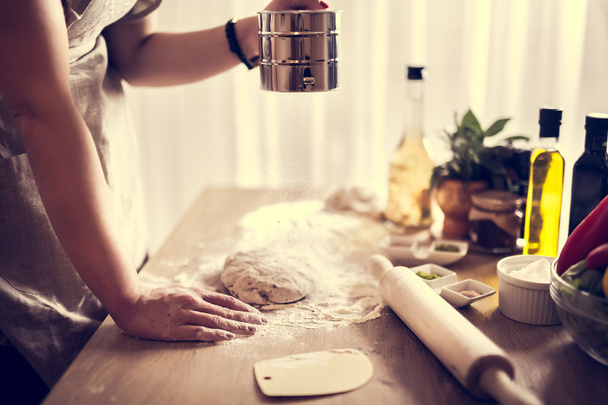 Woman preparing dough basis.Ingredients for baking.Female hands spilling powder on dough.Making dough by female hands.Cooking and baking concept - Foto, Imagen