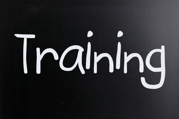 The word "Training" handwritten with white chalk on a blackboard - Photo, Image