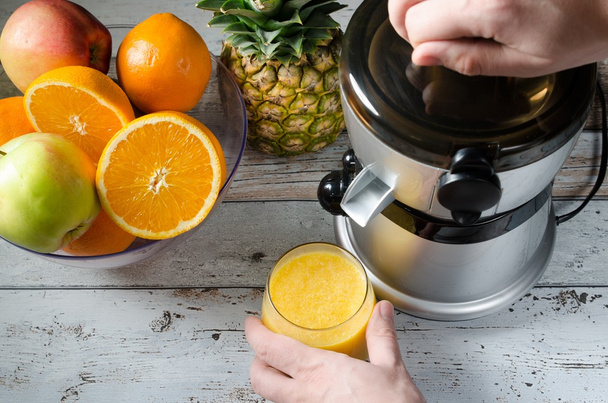 Man preparing fresh orange juice. Fruits in background - 写真・画像