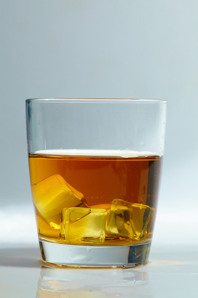 Whiskey with ice cubes in glass - Фото, изображение