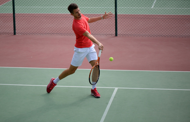 Joueur de tennis masculin pratiquant dans le court de tennis
 - Photo, image