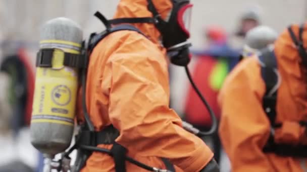 SAN PETERSBURG, RUSIA - 28 DE NOVIEMBRE DE 2015: Los hombres de color naranja protegen trajes, máscaras respiratorias. Un desastre químico. Tóxico
 - Imágenes, Vídeo
