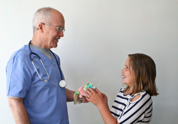 Médico dando presente para menina pré-adolescente
 - Foto, Imagem