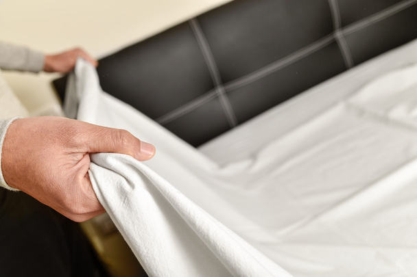 young man making the bed - Photo, Image