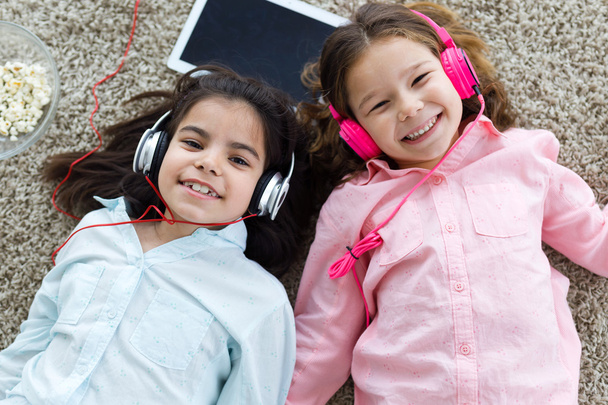 Όμορφη νεαρή αδελφές ακούγοντας μουσική με ψηφιακή δισκίο μια - Φωτογραφία, εικόνα
