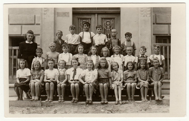 Archiwalne zdjęcie pokazuje uczniom (kolegów) oraz ich nauczycielka. - Zdjęcie, obraz