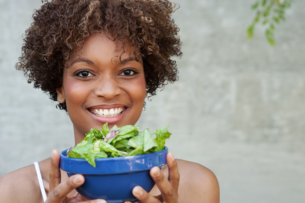 Pretty African American woman with salad, healthy lifestyle - Фото, изображение