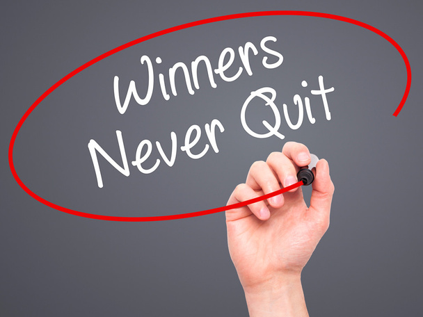 Man Hand writing Winners Never Quit with black marker on visual  - Photo, Image