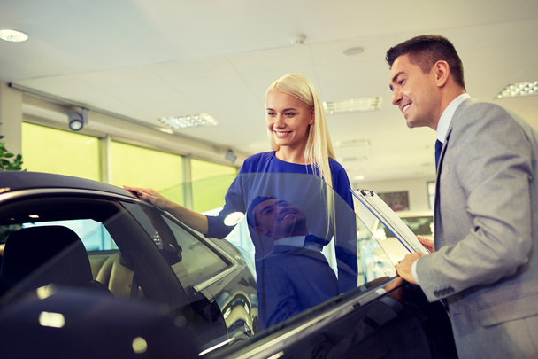 happy woman with car dealer in auto show or salon - Zdjęcie, obraz
