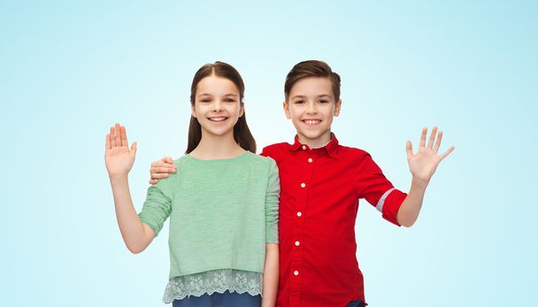 happy boy and girl waving hand - Foto, imagen