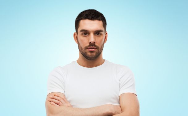 young man with crossed arms over blue background - Photo, image