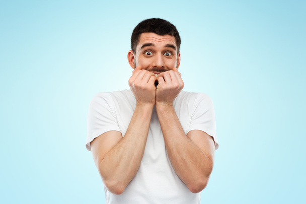 scared man in white t-shirt over blue background - Foto, immagini