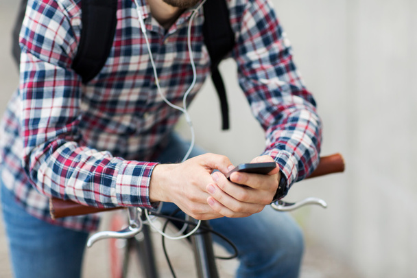 hipster man in earphones with smartphone and bike - Photo, Image