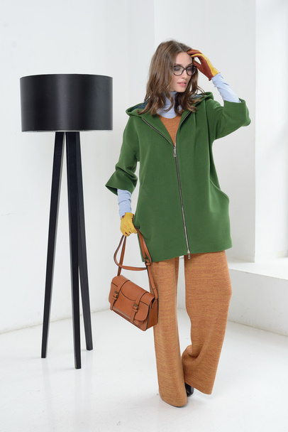 Girl in studio posing at coat - 写真・画像