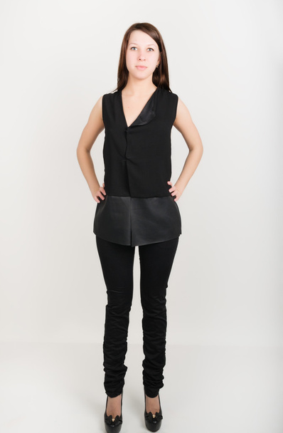 bela menina magro em calças pretas e uma blusa sem mangas preta
 - Foto, Imagem