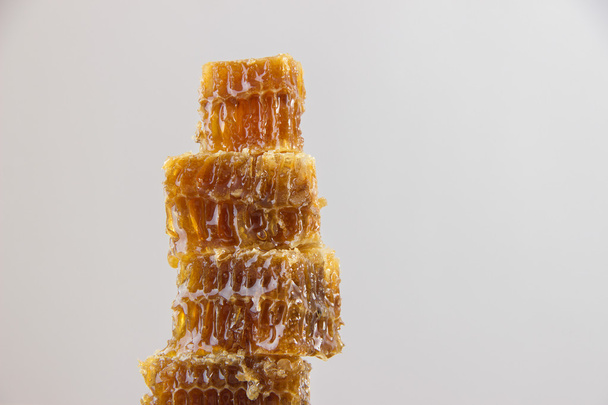 Goldener Honig in der Wabe in einem Glas und gelbe Zitronenscheiben - Foto, Bild