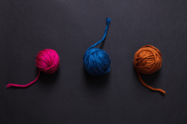 Colorful yarn clews on black background - Foto, imagen
