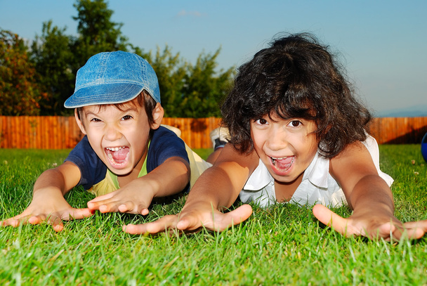 Happy children on beautiful green meadow - Fotó, kép