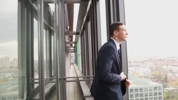 businessman standing by the window - Video