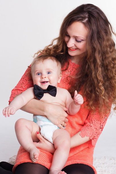 Beautiful mother holding baby boy in studio - Foto, Bild