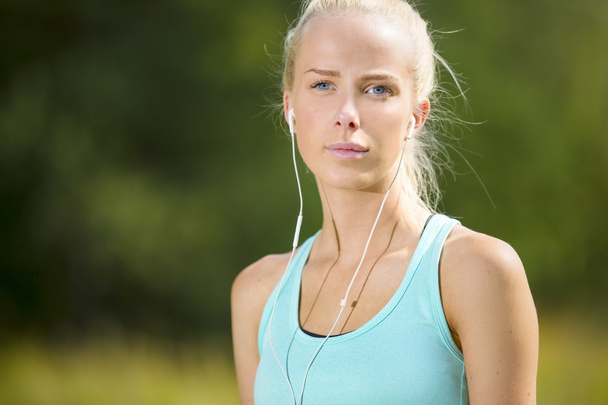 Blonde woman listen to music when she exercise - Photo, Image