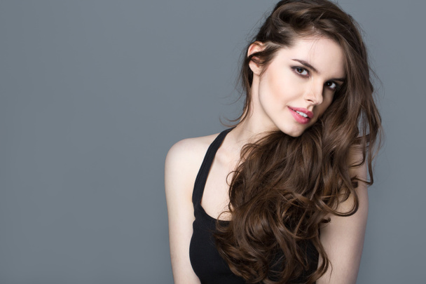 Beautiful woman model brunette with long curled hair. - 写真・画像