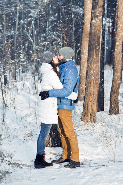 happy couple kissing in winter forest - 写真・画像