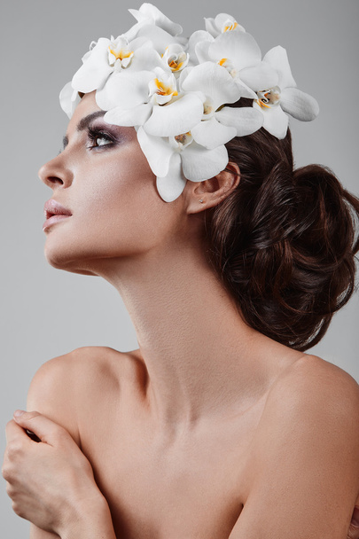 Πορτρέτο του όμορφο, λαμπερό, αισθησιακό μελαχρινή μοντέλο με λουλούδια - Φωτογραφία, εικόνα