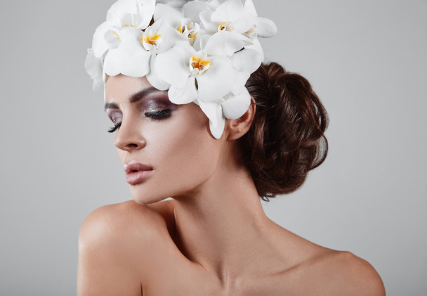Portret van mooie, glamoureuze, sensuele brunette model met bloemen - Foto, afbeelding