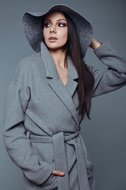 young fashion brunette woman beauty in gray coat and hat - Photo, image