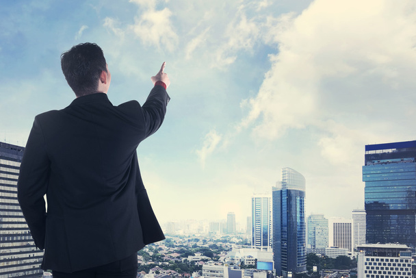 Empresário asiático olhando a cidade do telhado
 - Foto, Imagem