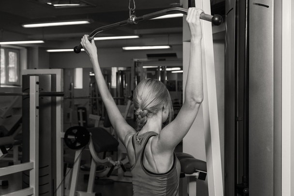 Κορίτσι αντλίες τις σημαντικότερες ομάδες μυών στο γυμναστήριο. Ασκήσεις ενδυνάμωσης. Γυναικεία fitness. Ισχυρή κορίτσι. - Φωτογραφία, εικόνα