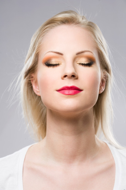 Young blond woman displaying elegant makeup. - Photo, image