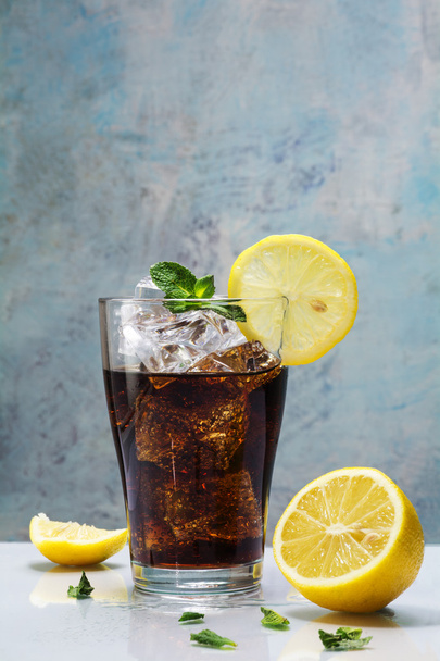 glass of cola or coke with ice cubes, lemon slices and peppermin - Fotó, kép