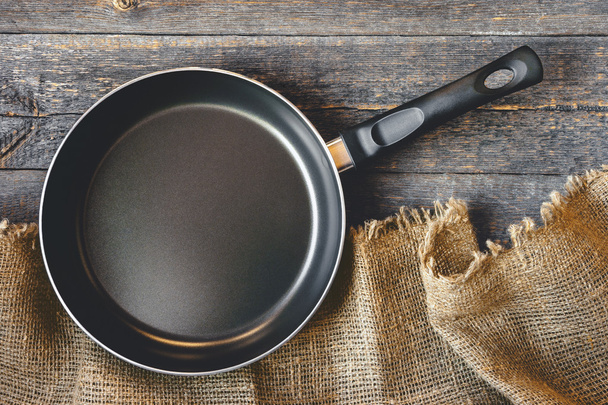 An empty pan on a wooden table - Foto, Bild