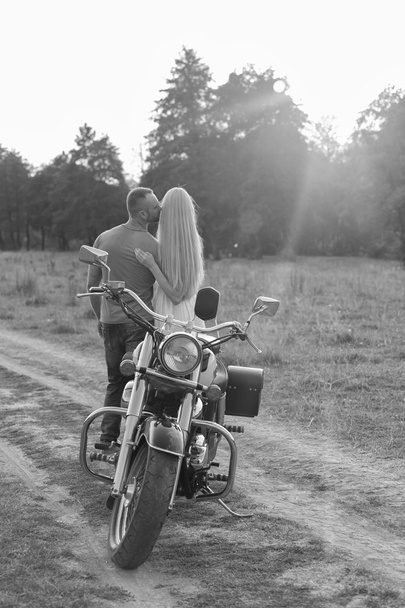 Black and white photo biker couple on a motorcycle in the field. - Foto, Imagen