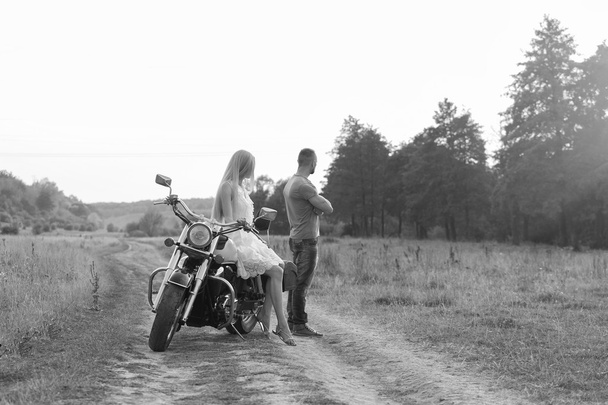 Blanco y negro foto motorista pareja en una motocicleta en el campo
. - Foto, imagen