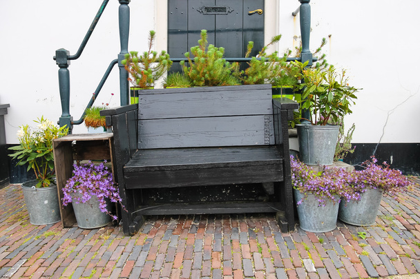 Tradycyjne holenderski drewniane ławki w otoczeniu roślin ozdobnych o - Zdjęcie, obraz