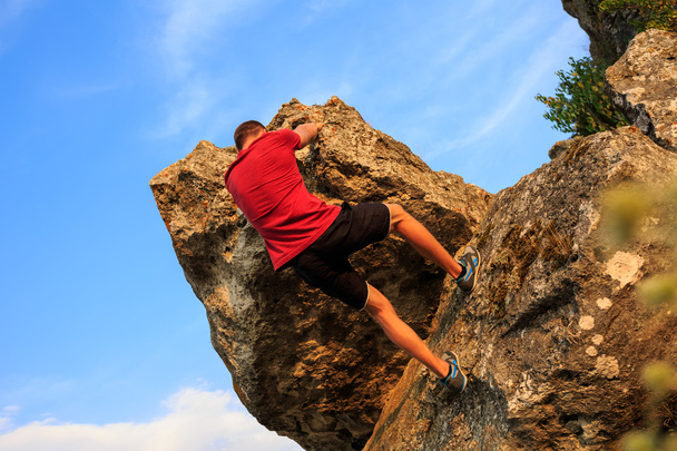 jonge man klimmen op een muur - Foto, afbeelding