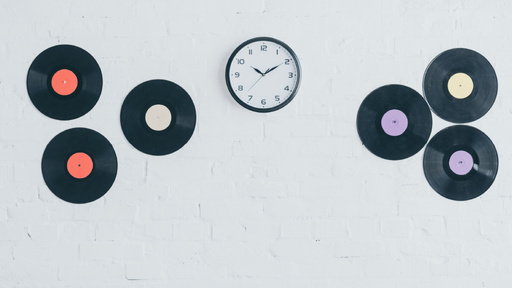 Clock And Vinyls On White Brick Wall 