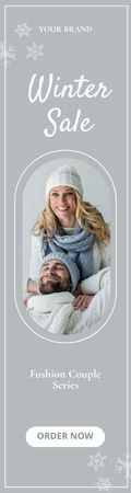 Platilla de diseño Winter Sale Ad with Couple in Warm Knitwear Skyscraper
