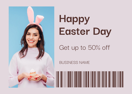 Platilla de diseño Smiling Woman in Easter Bunny Ears Holding Cupcake Card